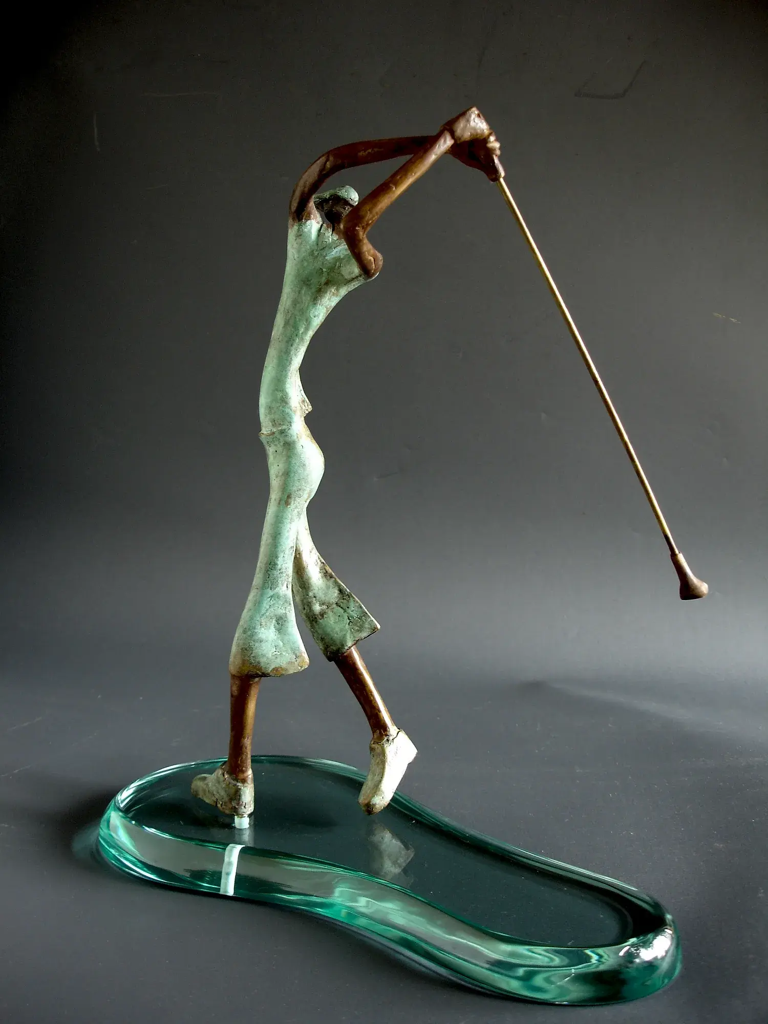 Golfer — bronze figure mid-swing on a wavy glass base