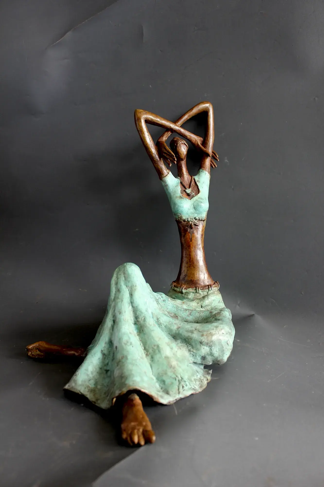 Alasya Kanya VI — bronze seated figure, arms raised overhead in a rounded arch