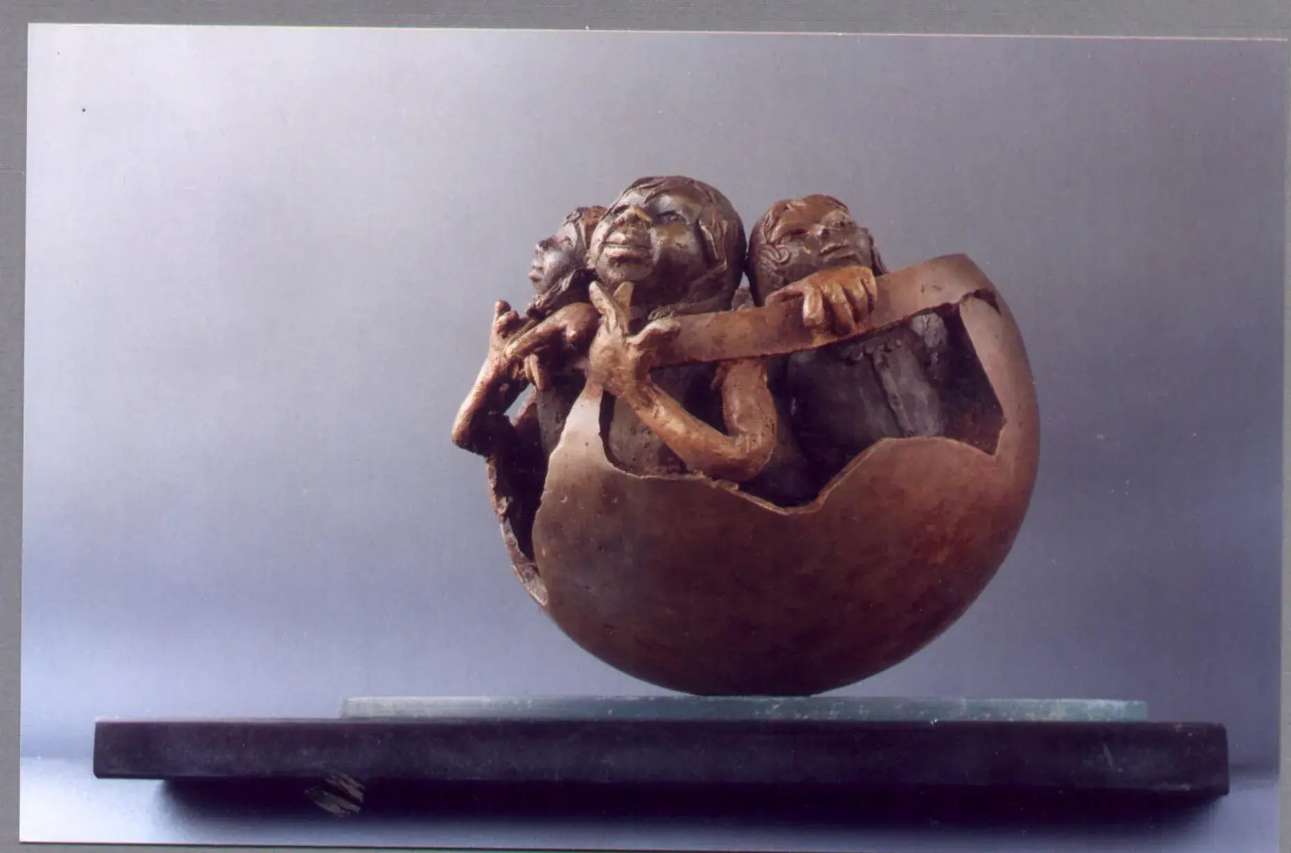 A Page From Our Family Album, alternate angle — the cracked bronze egg mounted on a black base with a glass disc