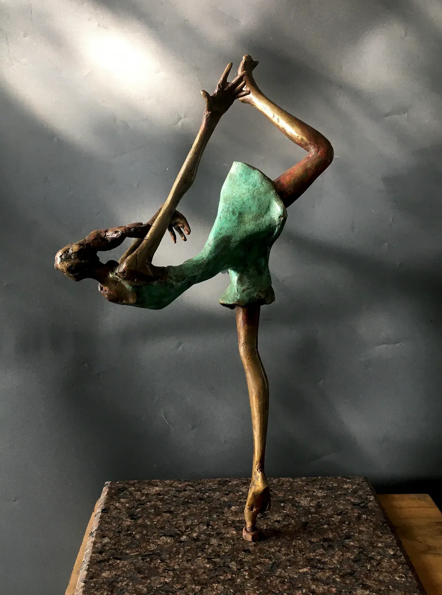 Bronze acrobat figure in an extreme handstand backbend, mint-green patina dress, on a granite base