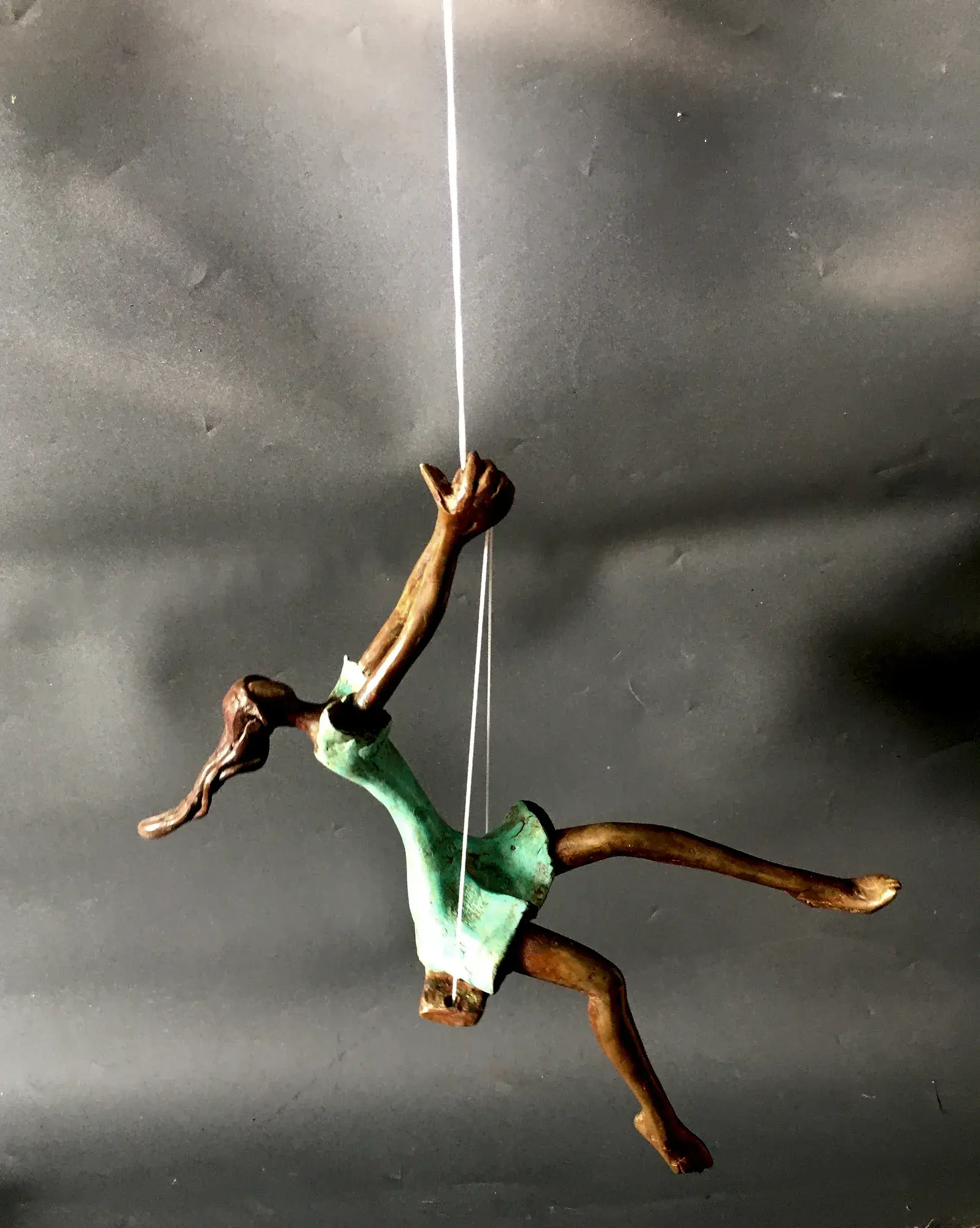 Swing, alternate angle — the wire-hung figure captured mid-leap