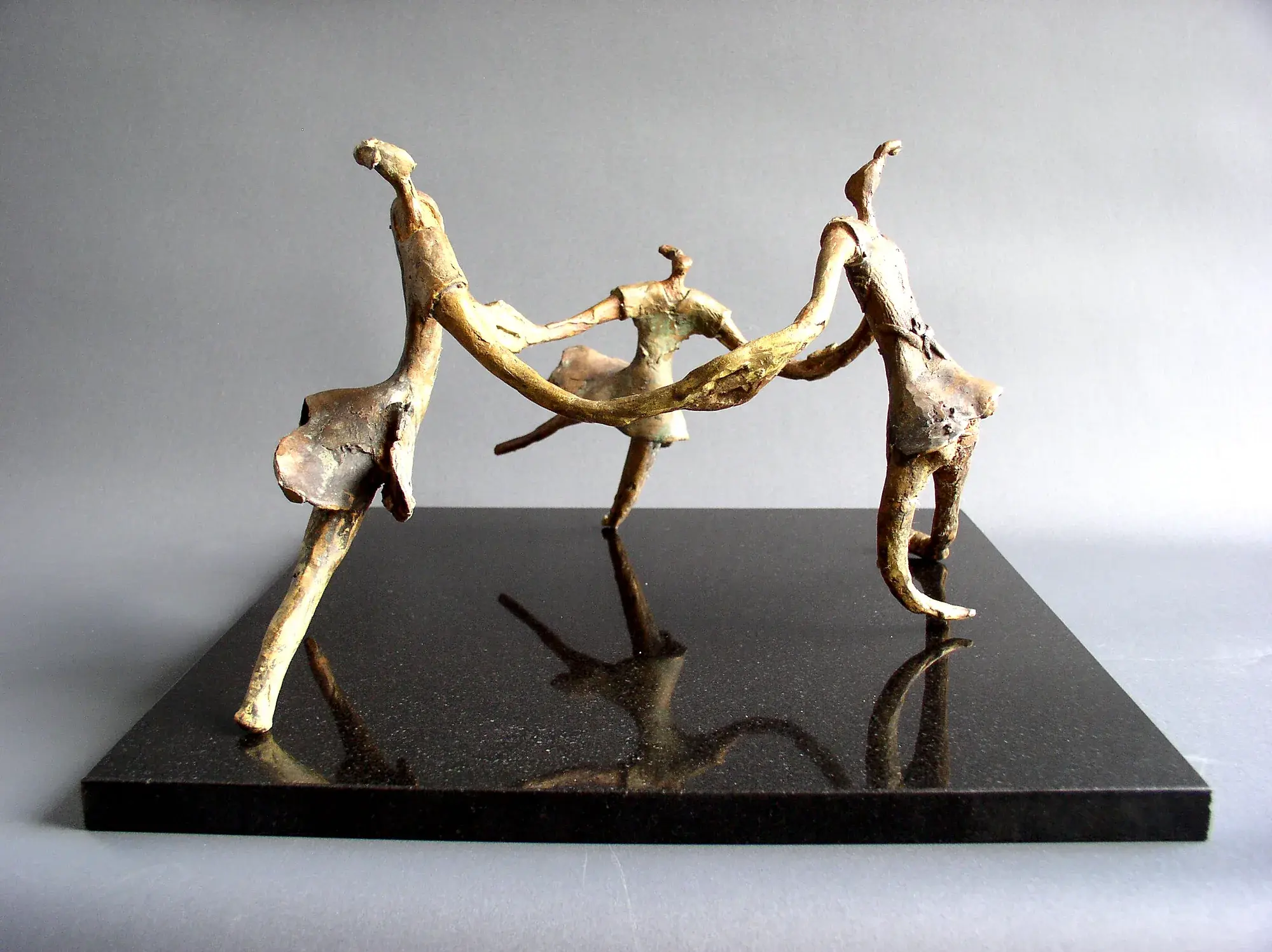 Swing — bronze figure suspended by wire in a dynamic climbing pose, mint-green patina dress